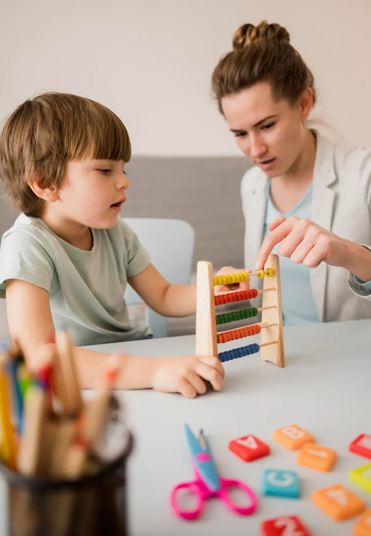 Niño practica un ejercicio cognitivo con ábaco junto a su terapeuta en Neuropser Medellín